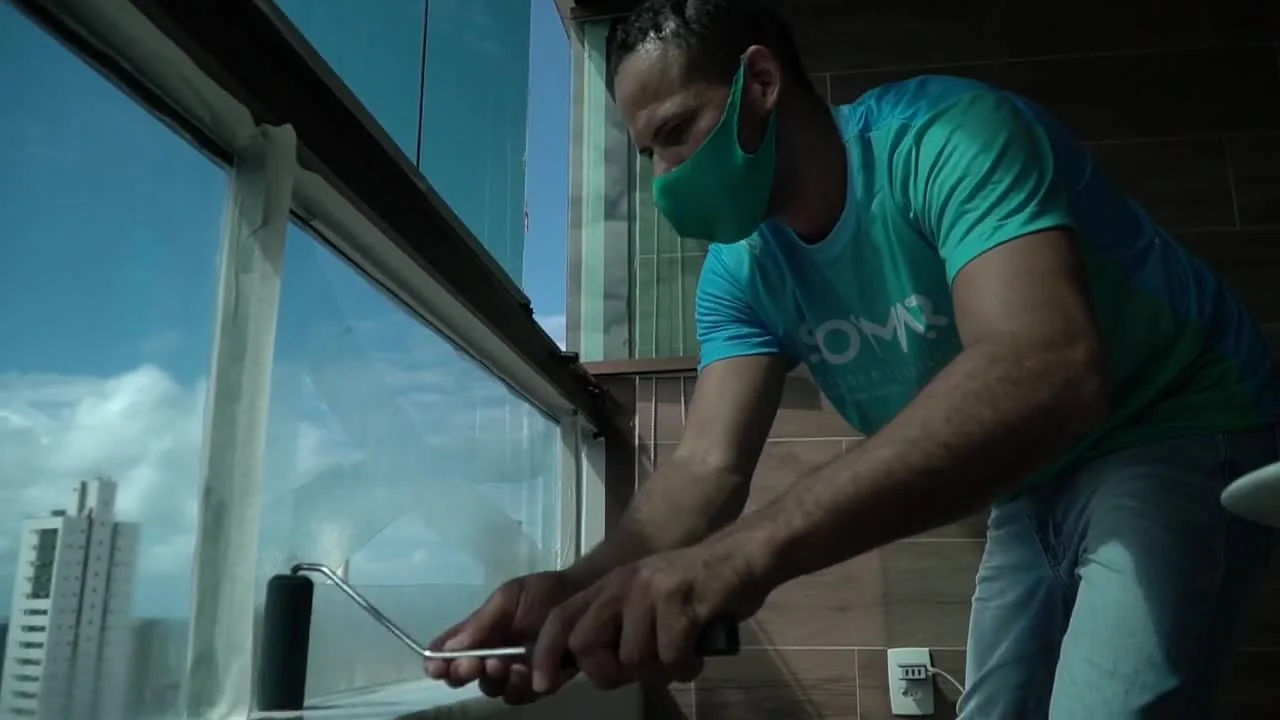 Aplicador da SOMMAR realizando aplicação da resina transparente Nanolux em vidro residencial